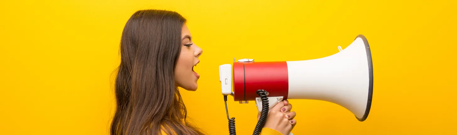 A woman with a megaphone talking Cover-Image-Outdoor-and-Indoor-display