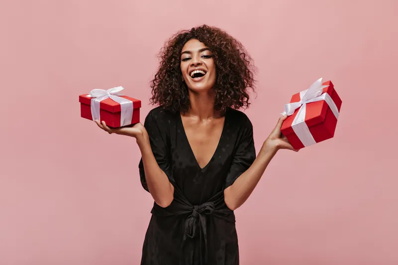 a lady holding two Year end gifts boxes on each hand