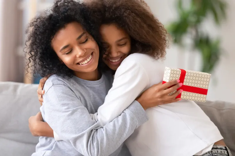 two young ladies hugging showing each other Year end gift appreciation