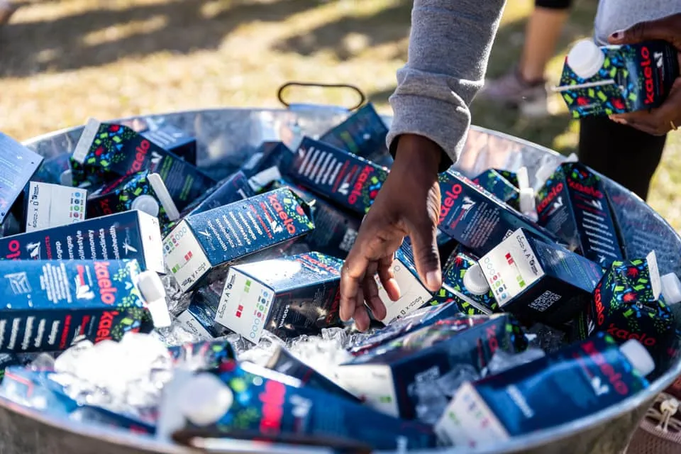 a person taking boxed water from a lot of boxed water packages