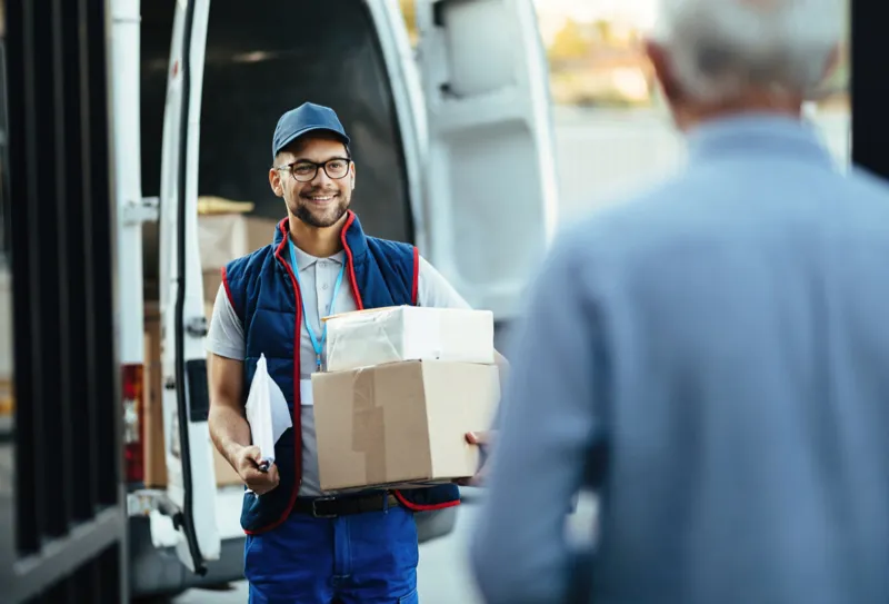 a man holding a delivery box wearing Ignition Marketing corporate uniform